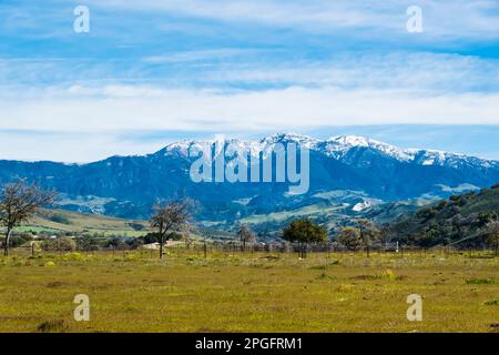 Die schneebedeckten Gipfel der Santa Ynez Berge im Winter, nachdem ein stimmungsvoller Fluss enorme Mengen an Feuchtigkeit in die Gegend brachte. Stockfoto