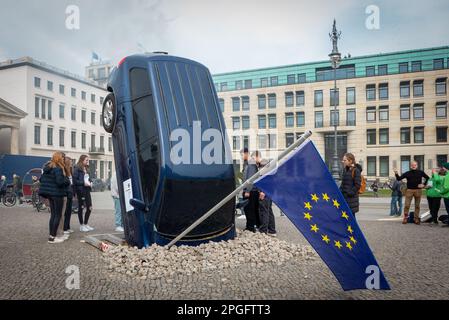 Autounfall: Greenpeace-Umweltaktivisten inszenierten vor dem Berliner Brandenburger Tor einen öffentlichen Protest gegen die europäische Klimapolitik und stellten ein abgestürztes Auto auf den Bürgersteig. "Hör auf, das Klima zu zerstören", liest ein Poster. Sie fordern dringende Klimaschutzmaßnahmen der europäischen Entscheidungsträger. Derzeit streiten sich Politiker und Industriellobbyisten in Berlin und Brüssel über die Zukunft von Kraftfahrzeugen. Stockfoto