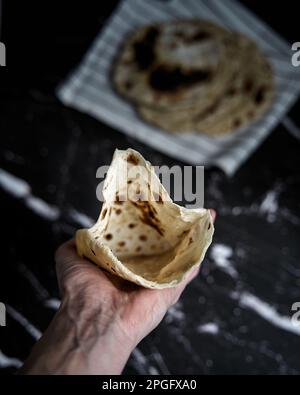 Gebratenes Pita-Brot in der Pfanne auf dunklem Hintergrund. Draufsicht Stockfoto