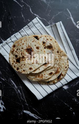 Gebratenes Pita-Brot in der Pfanne auf dunklem Hintergrund. Draufsicht Stockfoto