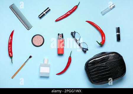 Mit Chili-Paprika und Zubehör auf blauem Hintergrund besprühen Stockfoto