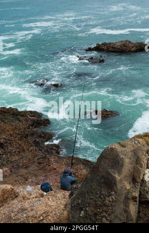 Ein Mann, der im Meer mit stürzenden Wellen angeln kann Stockfoto