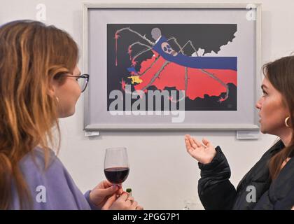 KRAKAU, POLEN - 22. MÄRZ 2023: Besucher sehen die Werke von Inna Linyova auf der Posterausstellung „Save the Future“, die am 22. März 2023 in der Provinzbibliothek in Krakau, Polen, eröffnet wurde. Inna Linyova, eine ukrainische Malerin und seit 2003 in den USA ansässige Grafikdesignerin, erstellt avantgardistische Kompositionen. Der Schmerz der Künstlerin für die Situation ihrer Heimat während des Krieges spiegelt sich in ihrer Arbeit wider, indem sie die Sprache der Plakate benutzt, um die Aufmerksamkeit auf den Albtraum zu lenken, der aus Russland in die Ukraine kam. Auf einem ihrer Plakate, "Schwangere Ukraine", wird die Heimat als Schutz einer schwangeren Frau dargestellt Stockfoto