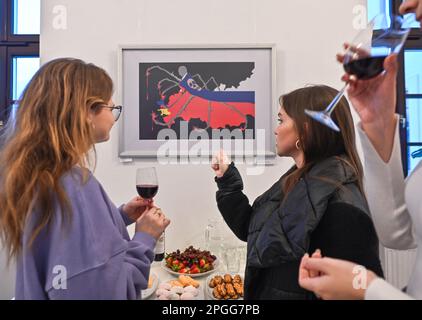 KRAKAU, POLEN - 22. MÄRZ 2023: Besucher sehen die Werke von Inna Linyova auf der Posterausstellung „Save the Future“, die am 22. März 2023 in der Provinzbibliothek in Krakau, Polen, eröffnet wurde. Inna Linyova, eine ukrainische Malerin und seit 2003 in den USA ansässige Grafikdesignerin, erstellt avantgardistische Kompositionen. Der Schmerz der Künstlerin für die Situation ihrer Heimat während des Krieges spiegelt sich in ihrer Arbeit wider, indem sie die Sprache der Plakate benutzt, um die Aufmerksamkeit auf den Albtraum zu lenken, der aus Russland in die Ukraine kam. Auf einem ihrer Plakate, "Schwangere Ukraine", wird die Heimat als Schutz einer schwangeren Frau dargestellt Stockfoto