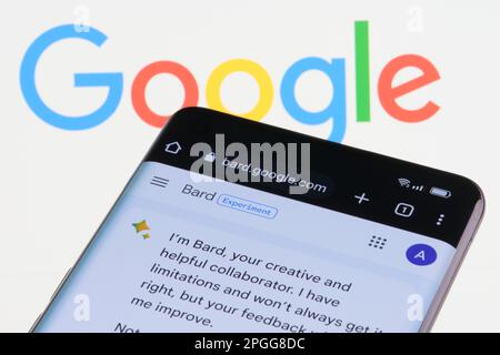 Google Bard AI-Chatbot. Ein echtes Beispiel für einen Chat-bot auf dem Bildschirm des Geräts und das Google-Logo im Hintergrund. Stafford, Großbritannien, 22. März 2023 Stockfoto