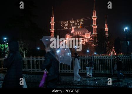 Istanbul, Istanbul, Türkei. 22. März 2023. Die Leute laufen auf dem Sultanahmet-Platz vor dem Ramadan. Der „Welcome, Sultan of Eleven Months“-Kamm wurde für Ramadan in der Blauen Moschee in Istanbul gehängt. (Kreditbild: © Tolga Uluturk/ZUMA Press Wire) NUR REDAKTIONELLE VERWENDUNG! Nicht für den kommerziellen GEBRAUCH! Stockfoto