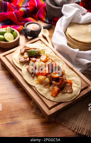 Fajitas Tacos, in Mexiko auch Alambre de Res genannt. Sehr beliebtes Rezept, die Hauptzutaten sind Fleisch, Zwiebeln, Speck und Paprika Stockfoto