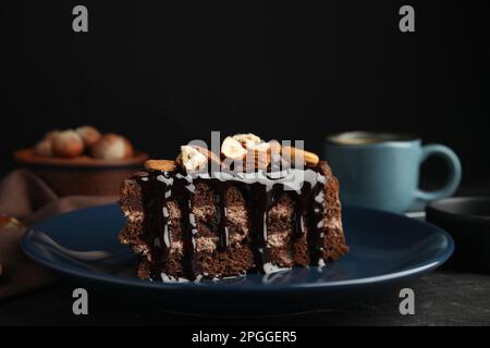 Ein Stück leckerer hausgemachter Schokoladenkuchen mit Nüssen auf einem schwarzen Tisch, Nahaufnahme. Platz für Text Stockfoto