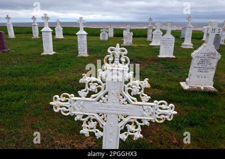 Ein kunstvoll verziertes Metallkreuz markiert ein Grab auf dem Friedhof am Meer in der Kirche Notre Dame du Mont Carmel am Mont Carmel, Prince Edward Island. Stockfoto