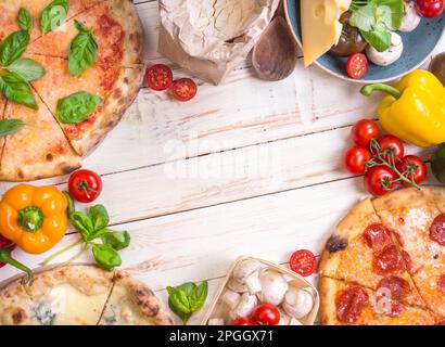 Pizza mit verschiedenen Belägen und Zutaten. Platz für Text. Pizza, Mehl, Käse, Tomaten, Basilikum, Peperoni, Pilze und Walznadel Stockfoto