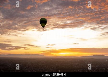Heißluftballon vor einem bunten Himmel und Wolken bei Sonnenaufgang in Melbourne, Victoria, Australien Stockfoto