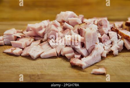 Speckscheiben in der Küche auf dem Schneidebrett, fertig zum Kochen. Stockfoto