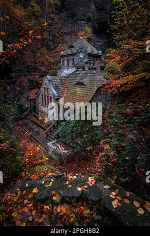 Hrensko, Tschechische Republik - schönes Steinhaus in den tschechischen Wäldern nahe Hresko im Herbst mit bunten Herbstblättern und Laub Stockfoto