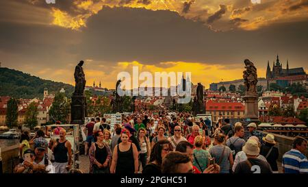 Prag, Tschechische Republik - riesige Touristenmassen überqueren die Karlsbrücke (Karluv Most) bei Sonnenuntergang Stockfoto