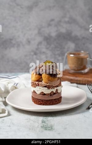 Mehrschichtiger Profiteroles-Kuchen. Schlagsahne, Schokolade und Pistazienkuchen. Stockfoto