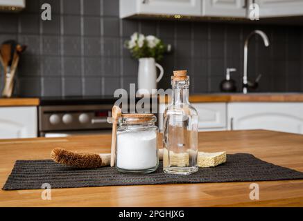 Verwendung von Natronlauge Natriumbicarbonat und Weißessig für die Hausküchenreinigung. Weißer Essig in Glasflasche und Backpulver in Glasbehälter. Stockfoto