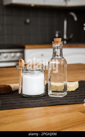 Verwendung von Natronlauge Natriumbicarbonat und Weißessig für die Hausküchenreinigung. Weißer Essig in Glasflasche und Backpulver in Glasbehälter. Stockfoto