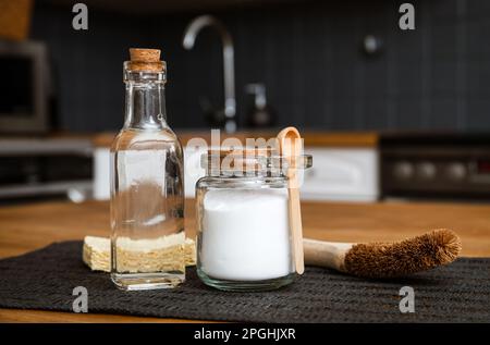 Verwendung von Natronlauge Natriumbicarbonat und Weißessig für die Hausküchenreinigung. Weißer Essig in Glasflasche und Backpulver in Glasbehälter. Stockfoto