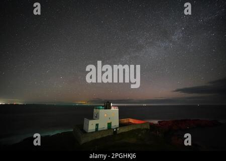 Der Milky Way liegt 3,00am m über dem Bamburgh Lighthouse in Northumberland an der Nordostküste Englands. Foto: Donnerstag, 23. März 2023. Stockfoto