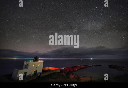 Der Milky Way liegt 3,00am m über dem Bamburgh Lighthouse in Northumberland an der Nordostküste Englands. Foto: Donnerstag, 23. März 2023. Stockfoto