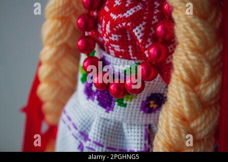 Holzpuppe im traditionellen ukrainischen Kleid auf blauem Hintergrund Stockfoto