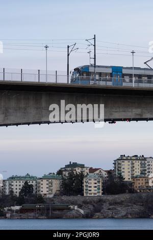 Ein moderner Personenzug fährt über eine Brücke in einer malerischen ländlichen Umgebung Stockfoto