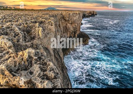 Die Klippen, auf denen die stürmischen Wellen des Meeres entlang der Küste des Naturschutzgebiets Plemmirio brechen. Im Hintergrund der Vulkan Ätna. Sizilien Stockfoto