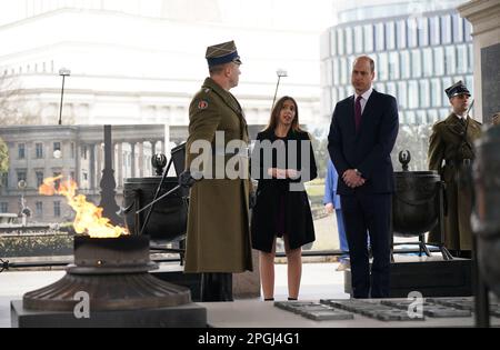 Der Prinz von Wales wird über das Grab des unbekannten Soldaten erzählt, ein Denkmal, das polnischen Soldaten gewidmet ist, die ihr Leben in Konflikten verloren, nachdem er einen Kranz legte, während seines Besuchs in Warschau, Polen. Bilddatum: Mittwoch, 22. März 2023. Stockfoto