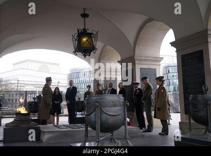 Der Prinz von Wales wird über das Grab des unbekannten Soldaten erzählt, ein Denkmal, das polnischen Soldaten gewidmet ist, die ihr Leben in Konflikten verloren, nachdem er einen Kranz legte, während seines Besuchs in Warschau, Polen. Bilddatum: Mittwoch, 22. März 2023. Stockfoto