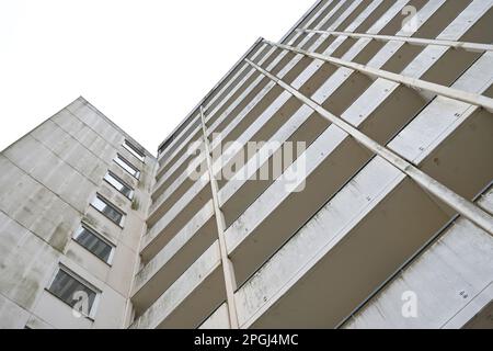 Fassade eines alten großen Hochhauses aus Beton mit Balkonen vor einem grauen Himmel, Konzept für Wohnungen und Immobilien, Kopierraum, Stockfoto