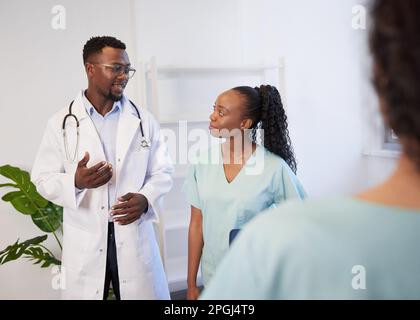 Über die Schulter-Aufnahme von zwei medizinischen Kollegen, die den Fall des Patienten diskutieren Stockfoto