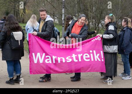 Dresden, Deutschland. 23. März 2023. Teilnehmer einer Kundgebung für den Warnstreik im öffentlichen Sektor halten ein Banner mit der Aufschrift „Warnstreik“ im Park „großer Garten“. In mehreren Städten und Landkreisen in Sachsen stellen Mitarbeiter des öffentlichen Sektors und Transportunternehmen ihre Arbeit ein. Kredit: Sebastian Kahnert/dpa/Alamy Live News Stockfoto