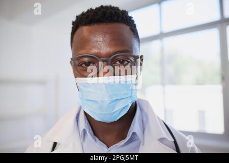Nahaufnahme von schwarzem männlichen Arzt mit chirurgischer Maske Stockfoto