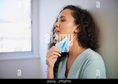 Junge Krankenschwester oder Arzt in Peelings lehnt sich an die Wand, überlastet gestresst Stockfoto