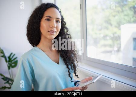 Porträt eines wunderschönen jungen Mediziners, der aus dem Krankenhausfenster schaut Stockfoto