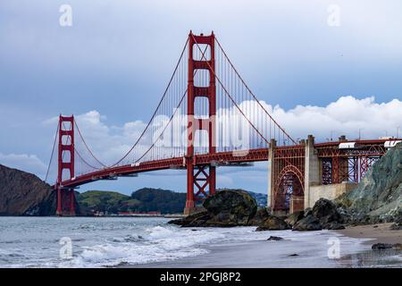 Die berühmte Golden Gate Bridge steht stolz über dem glitzernden Wasser des Strandes Stockfoto