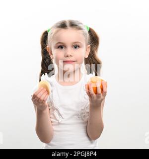 Tangerinen und Chips, gesund und schädlich, ein Mädchen mit einer Tangerine und Chips in den Händen auf weißem Hintergrund und Kopierbereich. Stockfoto