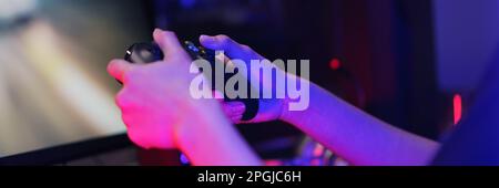 Die Hand einer weiblichen Cyber-Hacker-Gamer, die den Controller-Joystick hält, um Spiele auf dem Computer zu spielen. Stockfoto