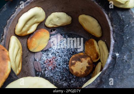 Tunis, Tunesien. 22. März 2023. Tunis, Tunesien, 22. März 2023. Tabouna-Brot wird in einem traditionellen Tonofen gekocht, bevor es auf einem Markt in Tunis verkauft wird. Tabouna ist ein altes tunesisches Brot aus Weizen-, Grieß- oder Gerstenmehl, das an den Wänden eines traditionellen Terrakotta-Ofens gekocht wird. Tabouna ist besonders beliebt während des heiligen muslimischen Monats Ramadan (Kreditbild: © Hasan mrad/IMAGESLIVE via ZUMA Press Wire). Nicht für den kommerziellen GEBRAUCH! Stockfoto