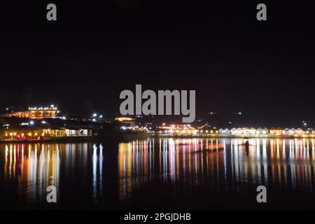 Lange Sicht über den See in Ban Rak Thai mit lichtdurchfluteten Pachtbooten. Stockfoto