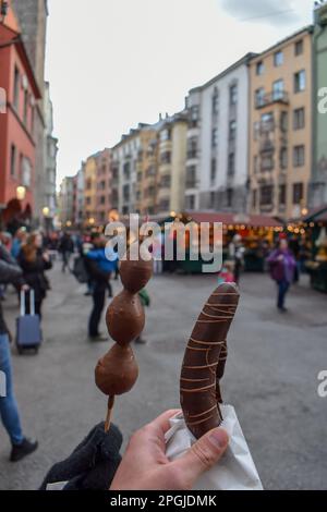 Schokoladenüberzogene Liebesäpfel zum Verkauf auf dem Weihnachtsmarkt in Innsbruck, Österreich. Christkindl Markt Stockfoto