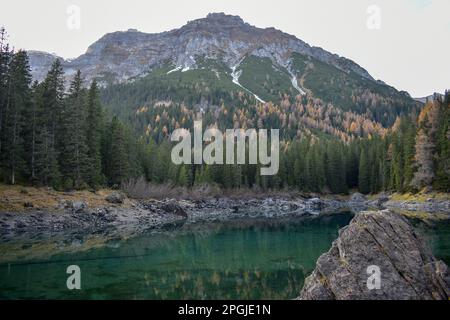 Atemberaubende Luftaufnahme der Dolomitenalpen bei sonnigem Herbsttag mit gelben Lärchen unten und Tal bedeckt von Nebel und hohen Berggipfeln dahinter. Corti Stockfoto