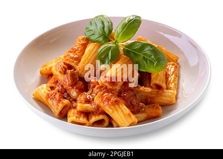 Makkaroni-Rigatoni mit Tomatensauce und Fleisch in weißer Schale mit Basilikumblättern, isoliert auf weißem Schneideweg Stockfoto