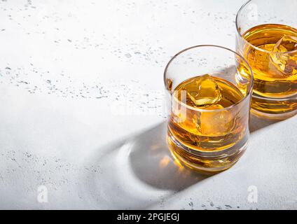 Zwei Whiskey-Gläser mit Eiswürfeln auf hellem Hintergrund. Makro Stockfoto