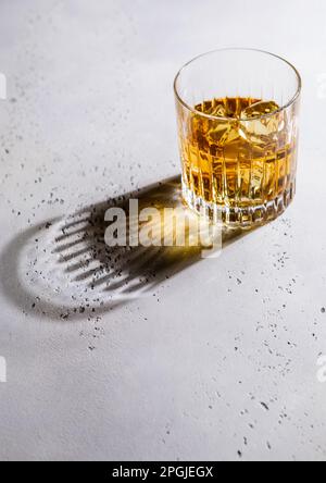 Whiskey aus Kristallglas mit Eiswürfeln und schwarzem Schatten. Stockfoto