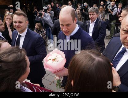 Der Prinz von Wales spricht mit Einheimischen, während er die Hala Koszyki Food Hall besucht, um junge ukrainische Flüchtlinge zu treffen, die jetzt in Polen leben und studieren, und Mitglieder der polnischen Gemeinde, die sie während seiner Reise nach Warschau, Polen, aufnehmen. Foto: Donnerstag, 23. März 2023. Stockfoto