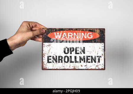 Offene Anmeldung. Warnschild mit Text auf weißem Hintergrund in der Hand einer Frau. Stockfoto