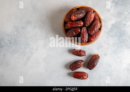 Datteln Sie Früchte in einer Holzschüssel auf hellem Hintergrund Stockfoto