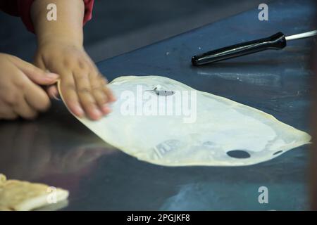 Roti in einer tiefen Bratpfanne, mit Granulatzucker bestreut und mit gesüßter Kondensmilch Stockfoto