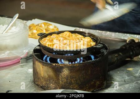 Roti in einer tiefen Bratpfanne, mit Granulatzucker bestreut und mit gesüßter Kondensmilch Stockfoto